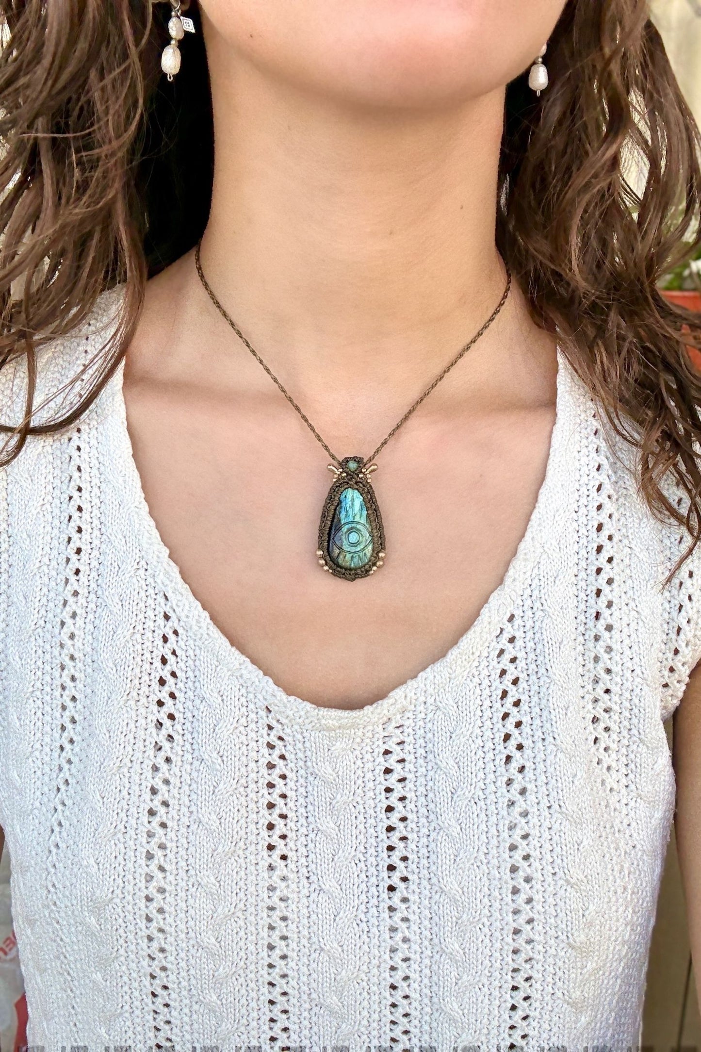 Model wearing handmade Labradorite protective eye necklace, showing how the jewelry rests on the neckline.
