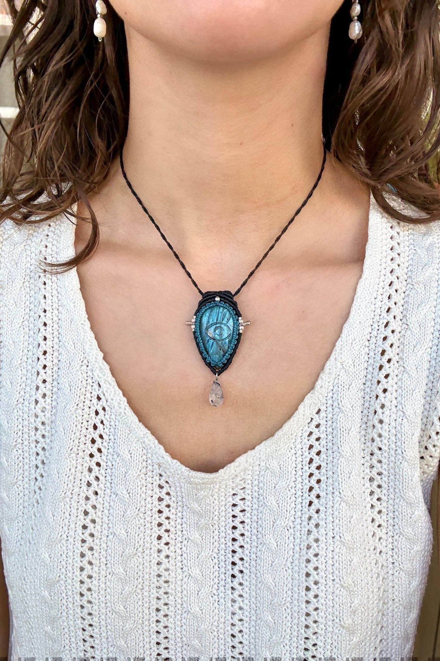 Model wearing handmade Labradorite protective eye necklace, showing how the jewelry rests on the neckline.