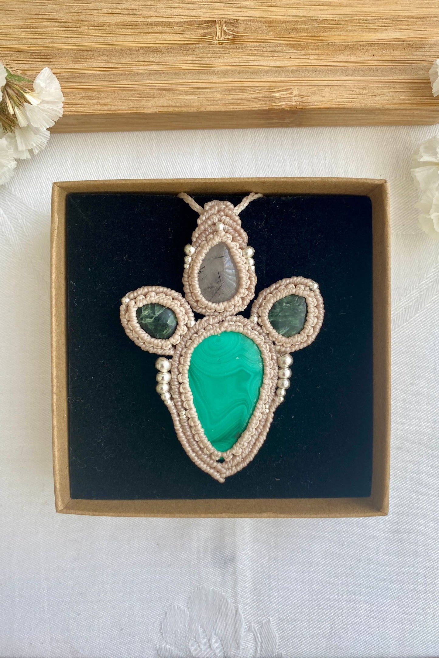Contrast view of the handcrafted macrame necklace, highlighting the detailed craftsmanship and the rich colors of Malachite and Seraphinite gemstones.