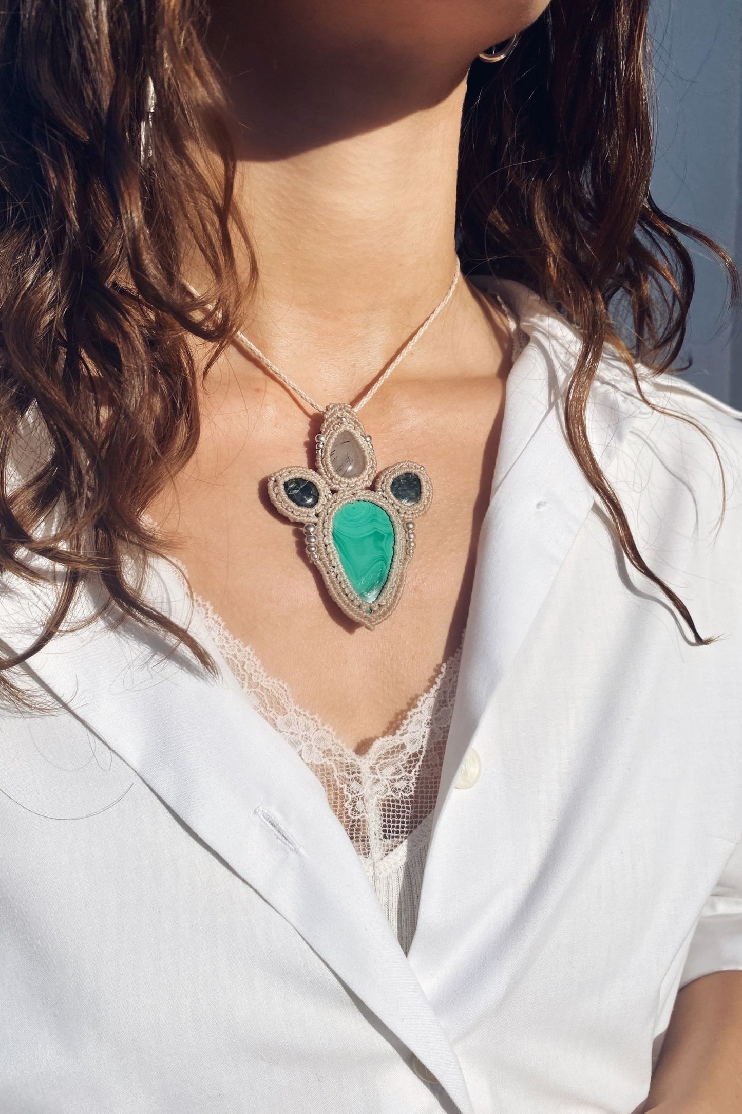 Handmade gemstone necklace worn, showing how the unique Malachite and Seraphinite pendant elegantly rests on the neckline.