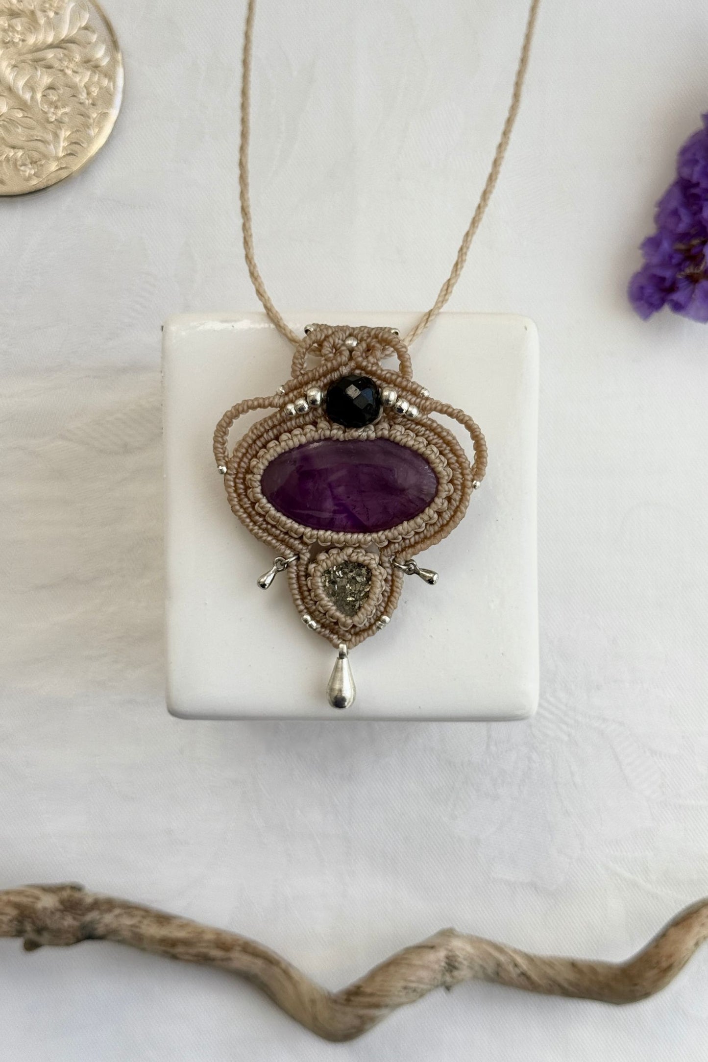 Handmade macrame necklace with Amethyst and Raw Druzy Pyrite gemstones, part of the Nocturnal Collection. One-of-a-kind design, laid flat for an artistic display.
