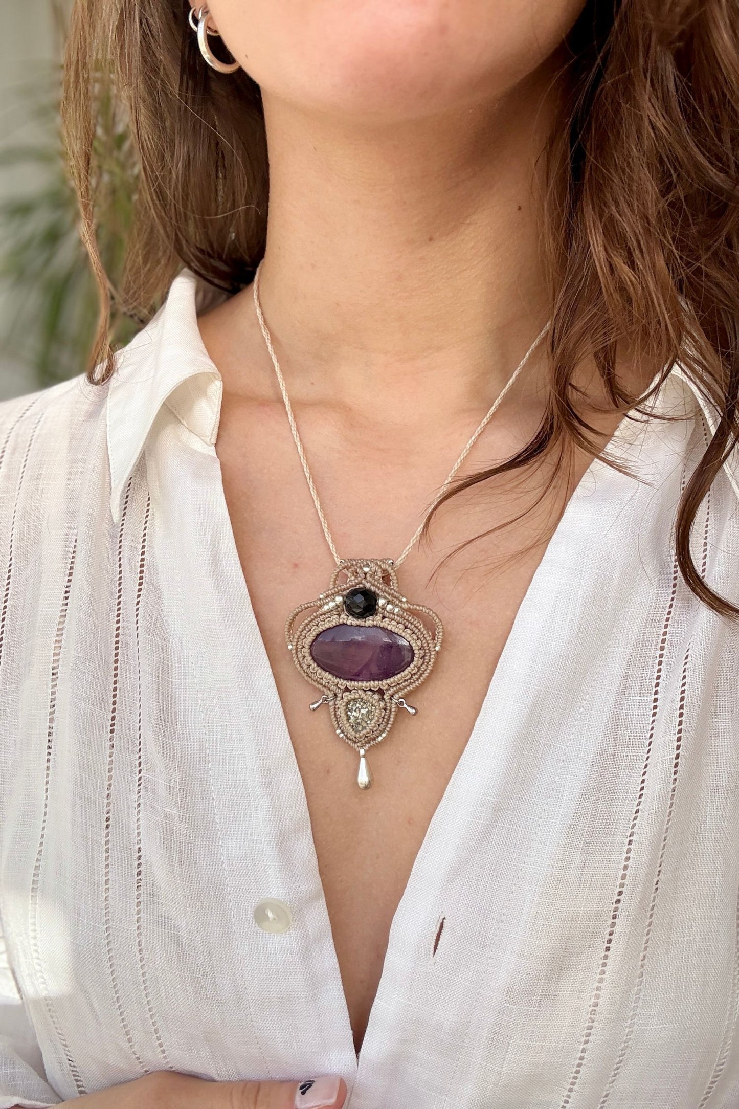 Amethyst and Raw Druzy Pyrite macrame necklace worn by a model. Showcasing the unique handmade design and how it looks when worn.