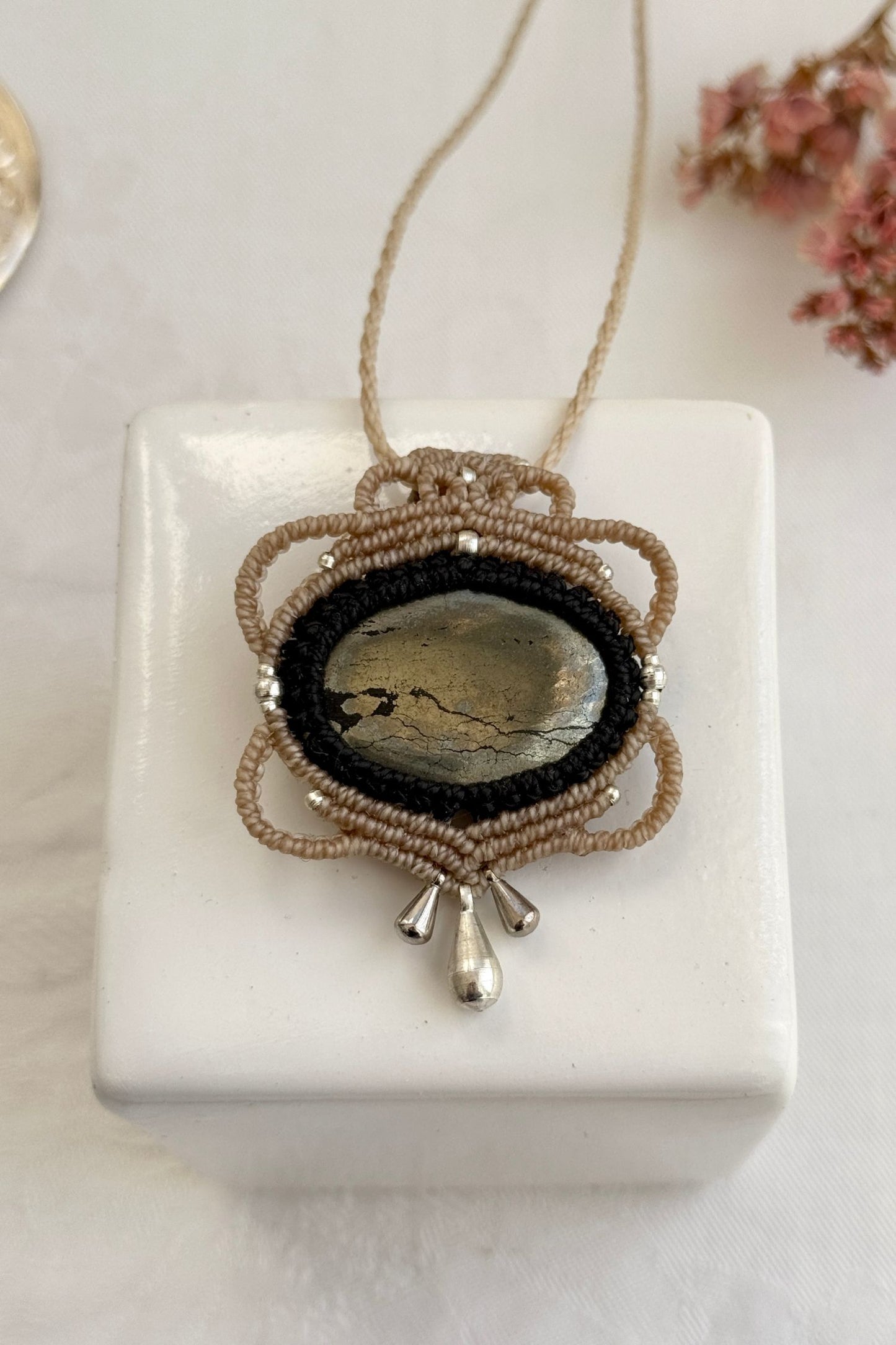 Handmade macrame necklace with Pyrite mirror-like silver surface gemstone, part of the Nocturnal Collection. One-of-a-kind design, laid flat for an artistic display.