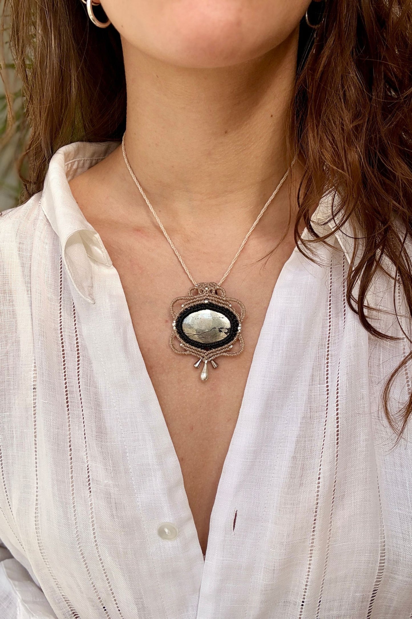 Pyrite macrame necklace worn by a model. Showcasing the unique handmade design and how it looks when worn.