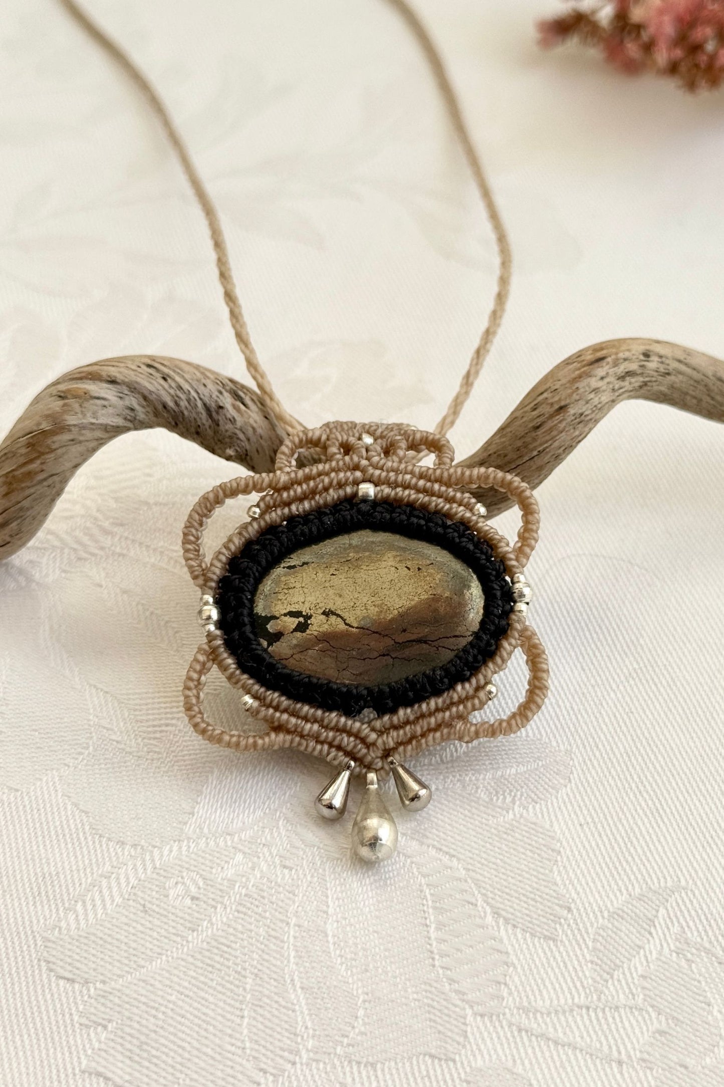 Close-up of the Pyrite macrame necklace in a unique setting. Highlighting the craftsmanship and gemstone details.