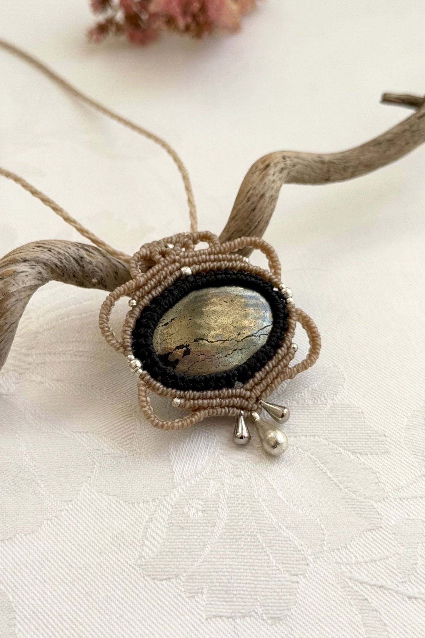 Side-angle view of the handmade macrame necklace with Pyrite. Showcasing depth, knotting details, and stone textures.