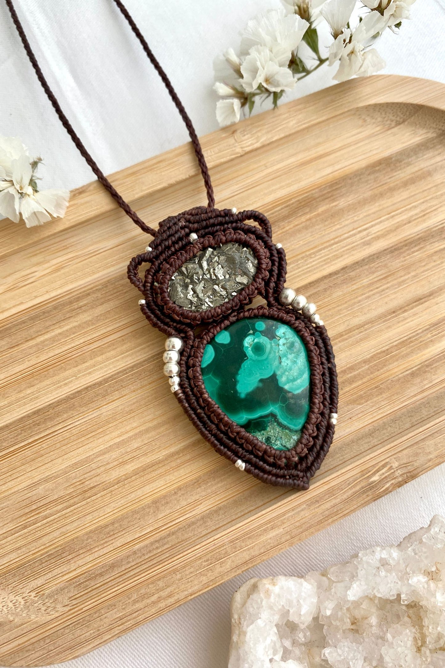 Close-up view of handmade macrame necklace with detailed malachite stone and raw pyrite, showcasing intricate macrame design.