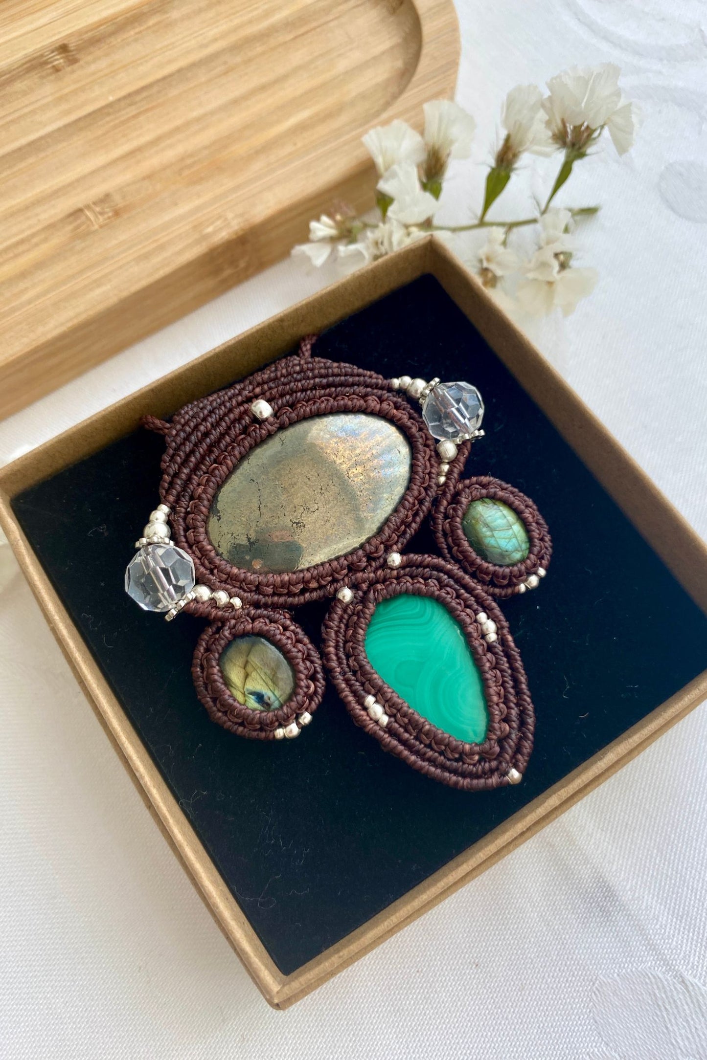 Side angle of the handcrafted macrame necklace, highlighting the detailed craftsmanship and the rich colors of Pyrite, Labradorite, Malachite and Quartz gemstones.