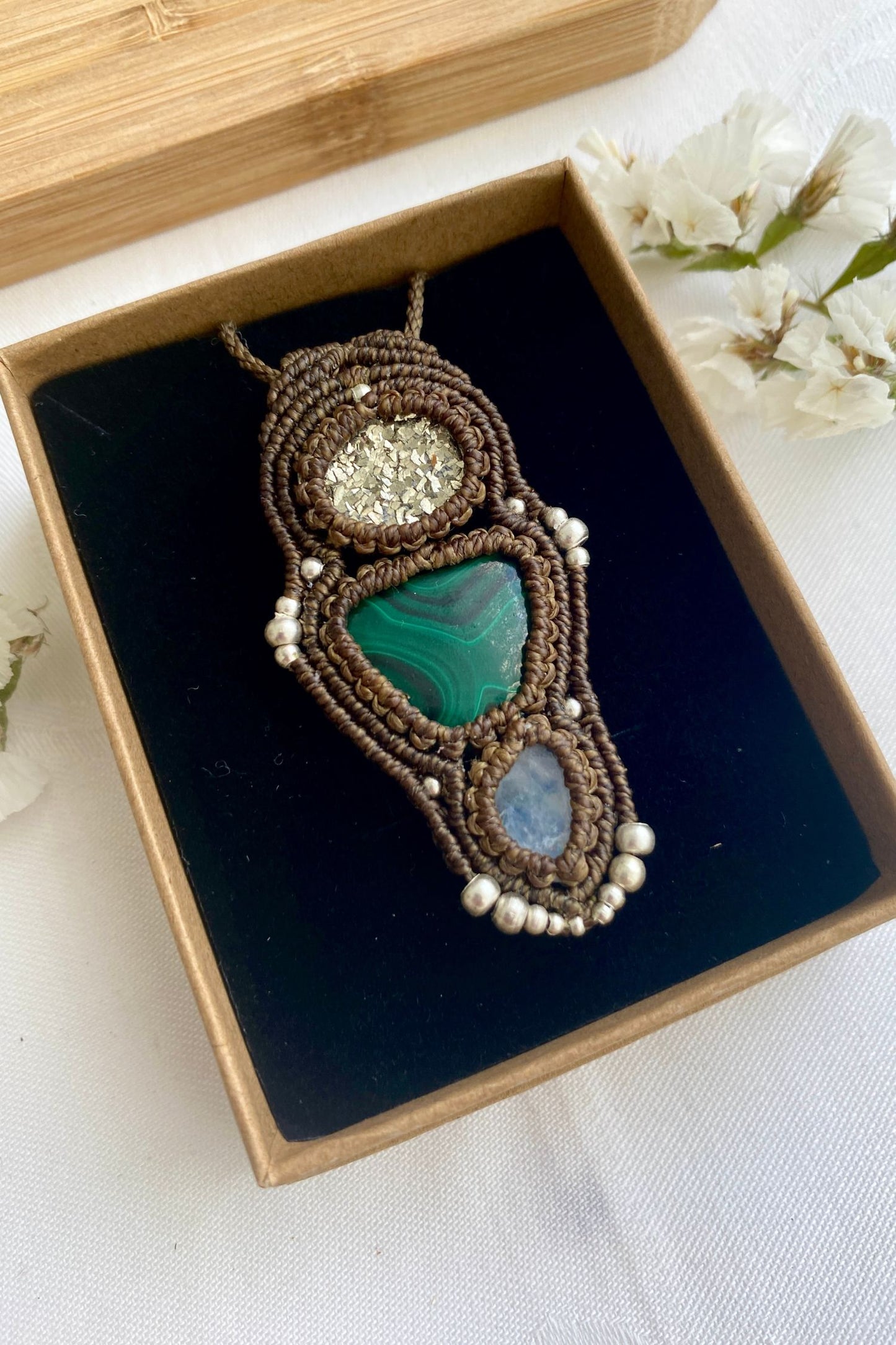 Detailed view of the handmade necklace, highlighting the raw textures of natural Pyrite, Malachite and Moonstone gemstones in a distinctive, statement-making design.