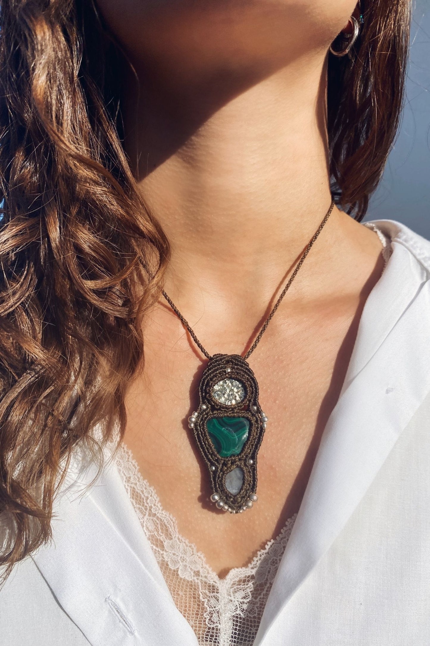 Handmade gemstone necklace worn, showing how the unique Raw Pyrite, Malachite and Moonstone pendant elegantly rests on the neckline.