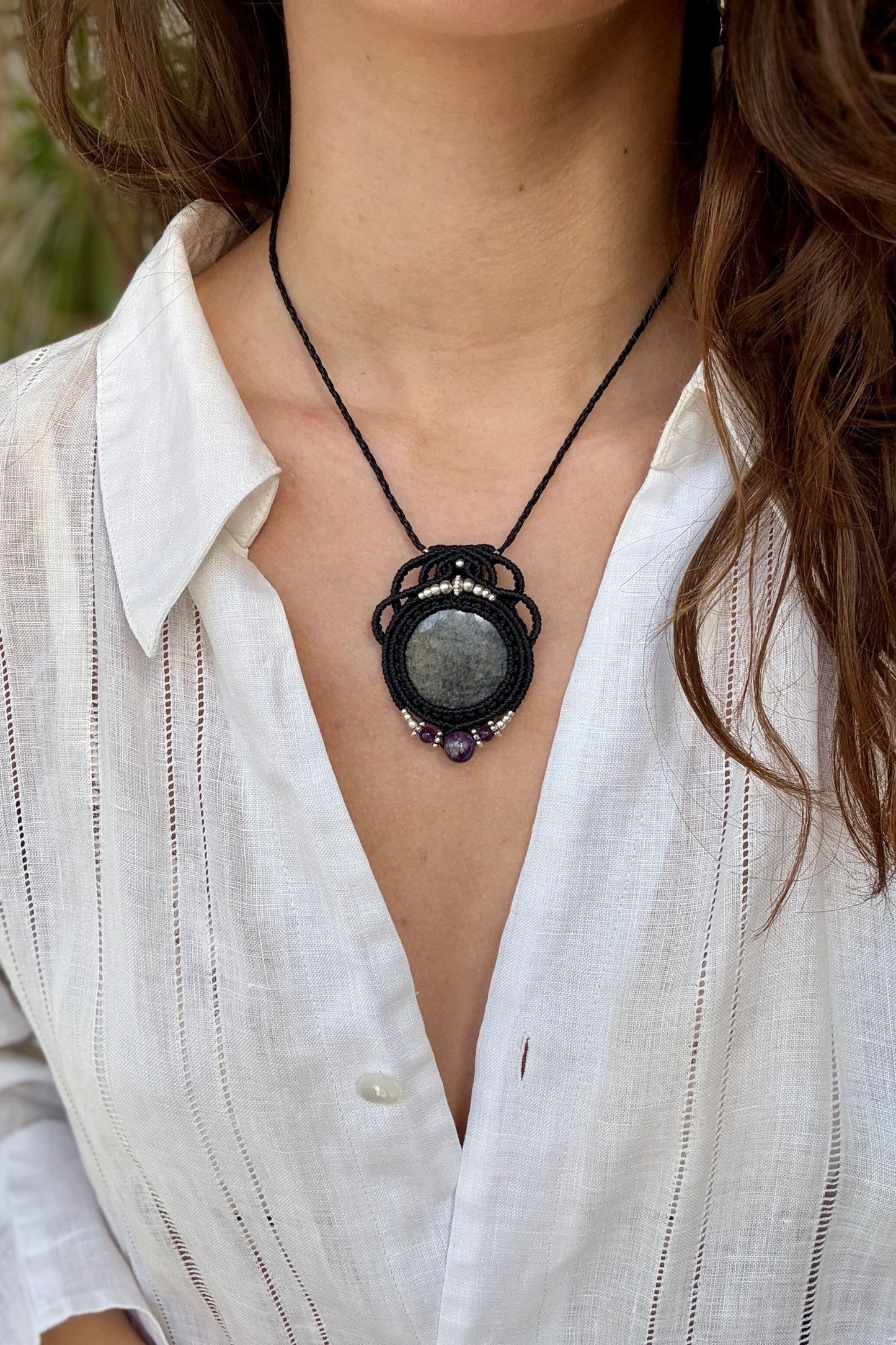Silver Sheen Obsidian and Amethyst macrame necklace worn by a model. Showcasing the unique handmade design and how it looks when worn.