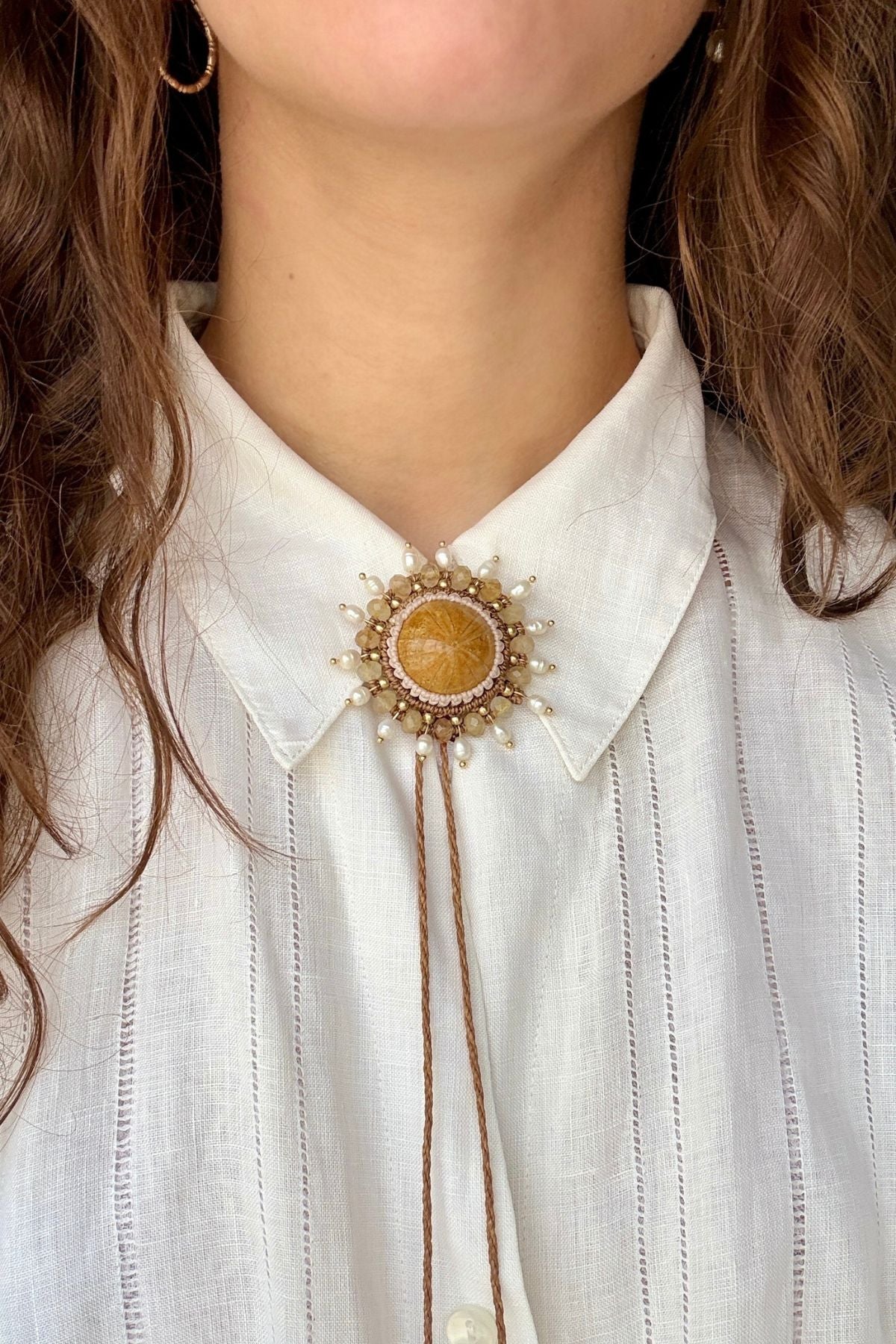 Sea urchin fossil bolo tie with freshwater pearls and faceted rutilated quartz worn at shirt collar, ocean inspired statement accessory