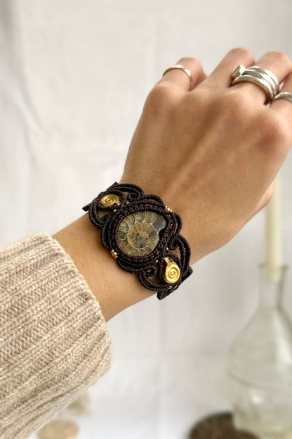 Yellow ammonite cuff bracelet worn on wrist with spiral brass accents, one of a kind fossil statement jewelry