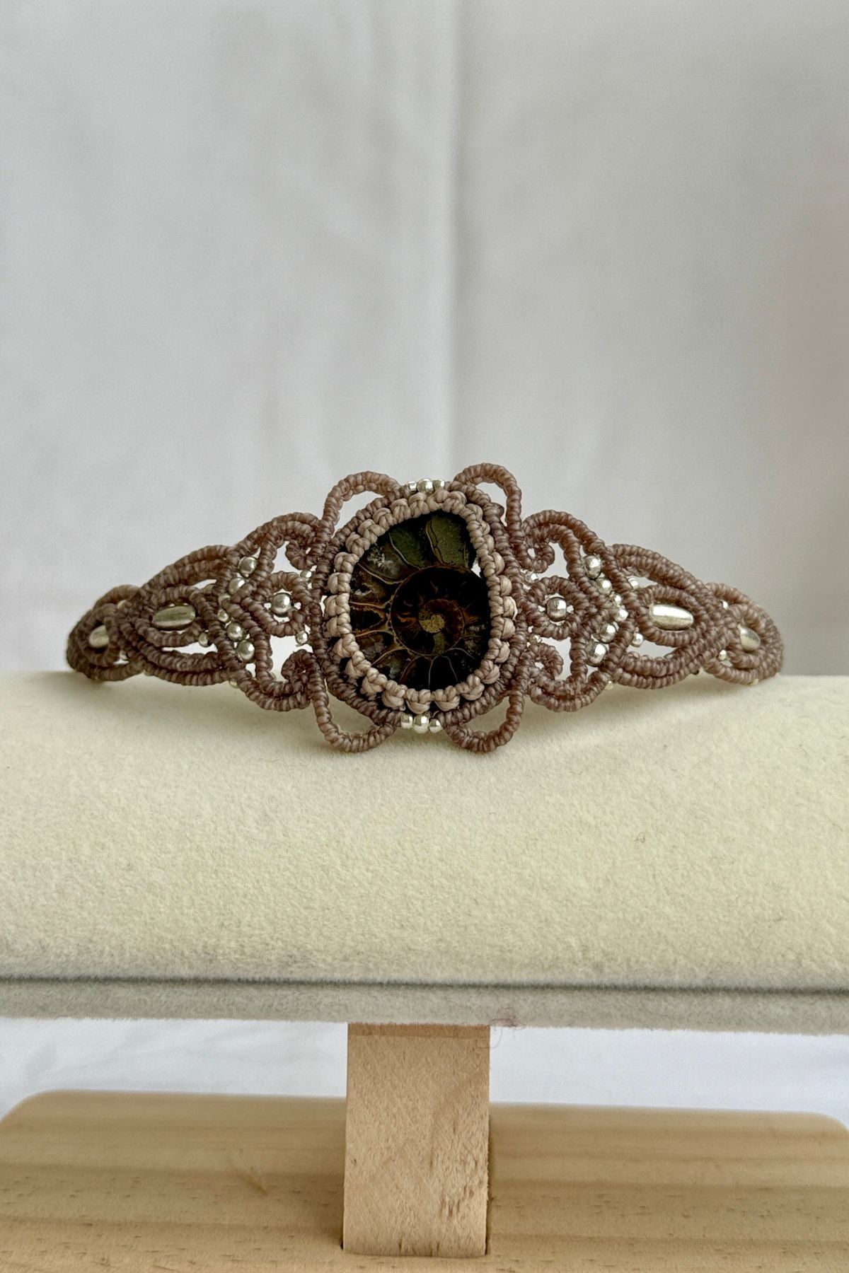 Sliced ammonite cuff bracelet displayed open, highlighting sculptural shape and natural fossil details