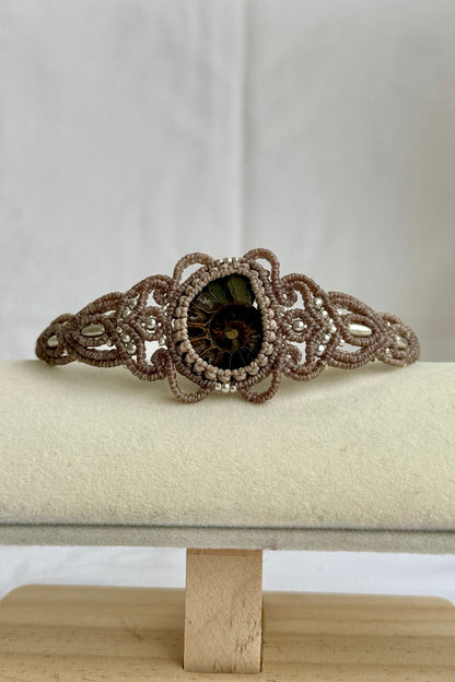 Sliced ammonite cuff bracelet displayed open, highlighting sculptural shape and natural fossil details