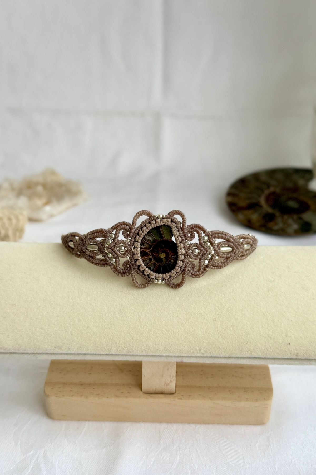 Ammonite fossil cuff bracelet shown from a distance to highlight proportions and bold statement design