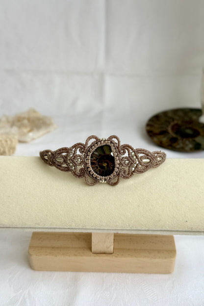 Ammonite fossil cuff bracelet shown from a distance to highlight proportions and bold statement design