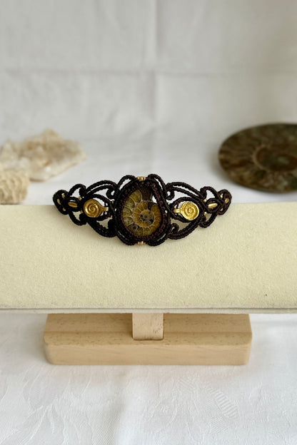 Yellow ammonite cuff bracelet shown from a distance to highlight proportions and bold spiral fossil centerpiece