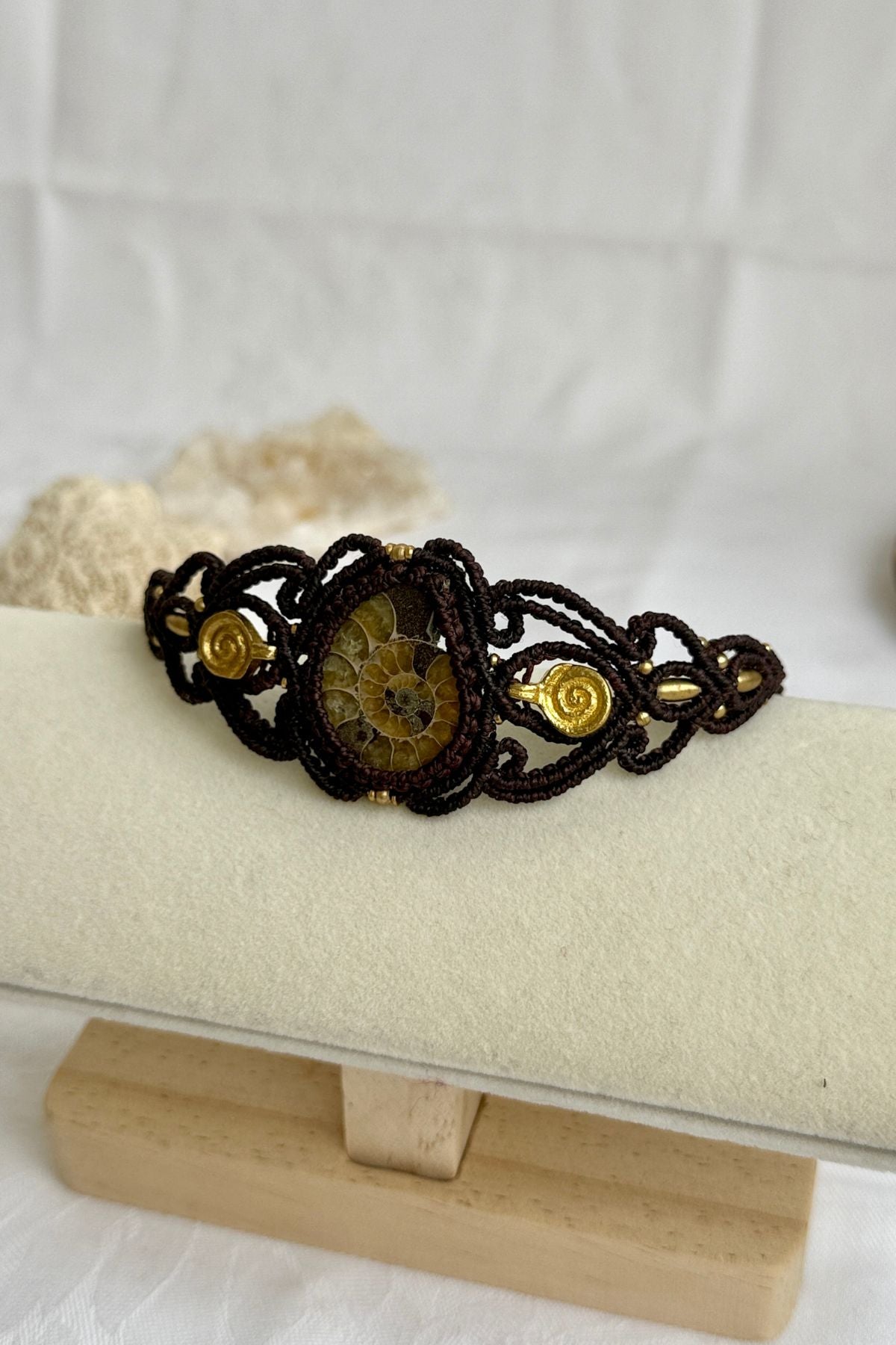 Side view of yellow ammonite cuff bracelet showing spiral brass elements and sculptural open design