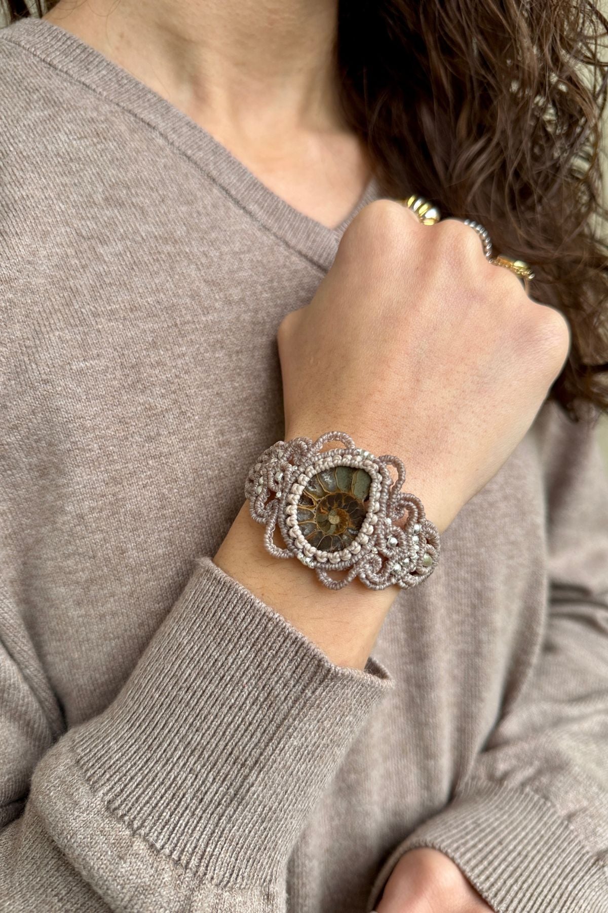 Model wearing sliced ammonite cuff bracelet, sculptural fossil statement jewelry