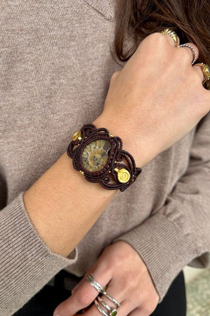 Yellow ammonite cuff bracelet styled with contrasting outfit, highlighting earthy tones and spiral brass details