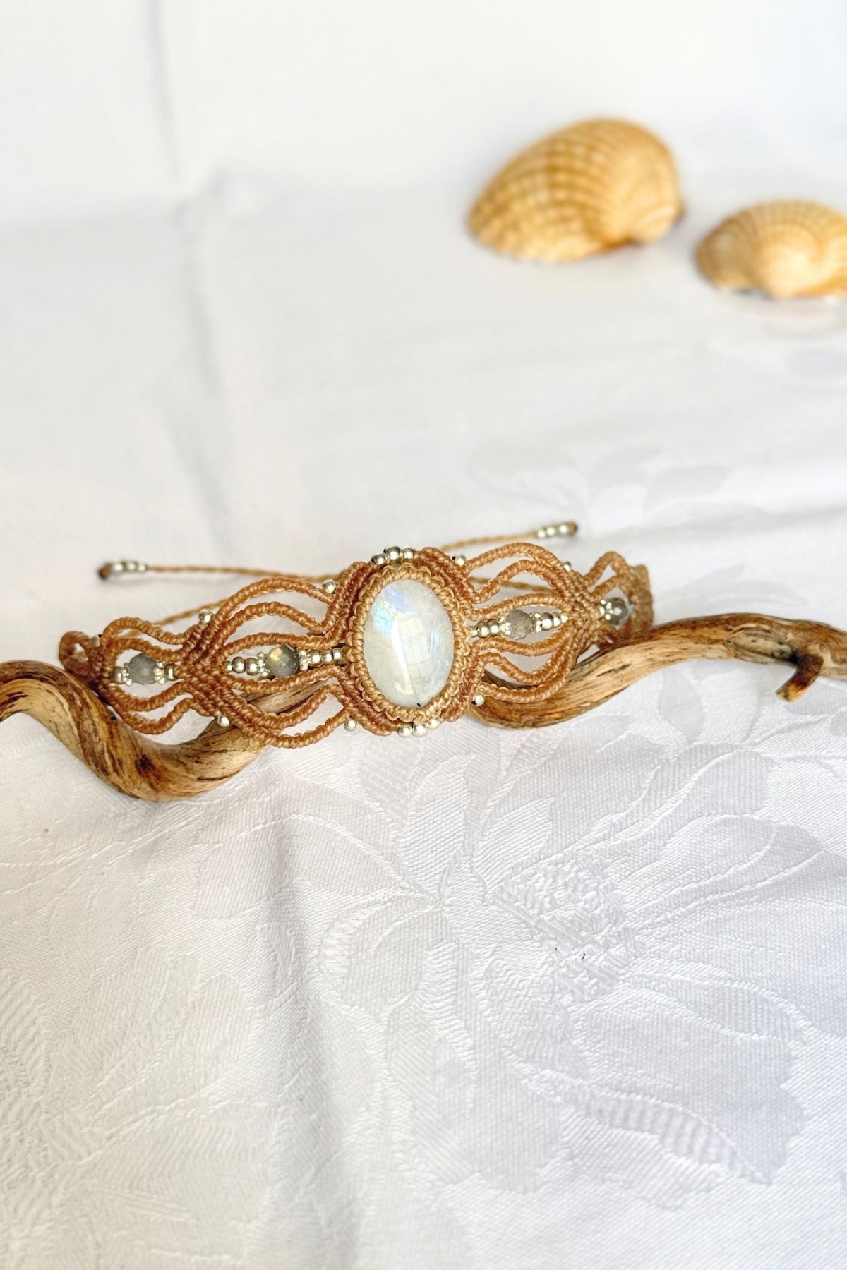 Angled view of the Moonstone and Labradorite bracelet, showing the oval centre stone and flowing macrame loops.