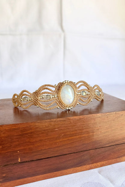 Rainbow Moonstone and Labradorite cuff bracelet viewed at an angle on a wooden box, showing the layered macrame design.