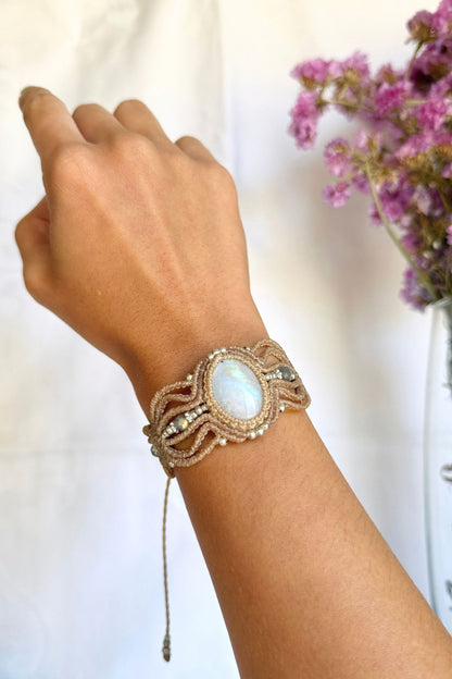 Close-up of the bracelet on a wrist, highlighting the Moonstone’s blue sheen, Labradorite beads and intricate macrame knots.