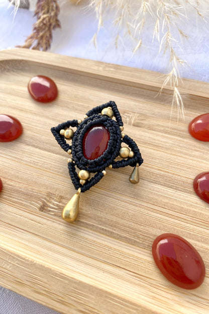 Side view of the handmade statement brooch, showcasing the three-dimensional effect of the Carnelian gemstone and golden drop accents.