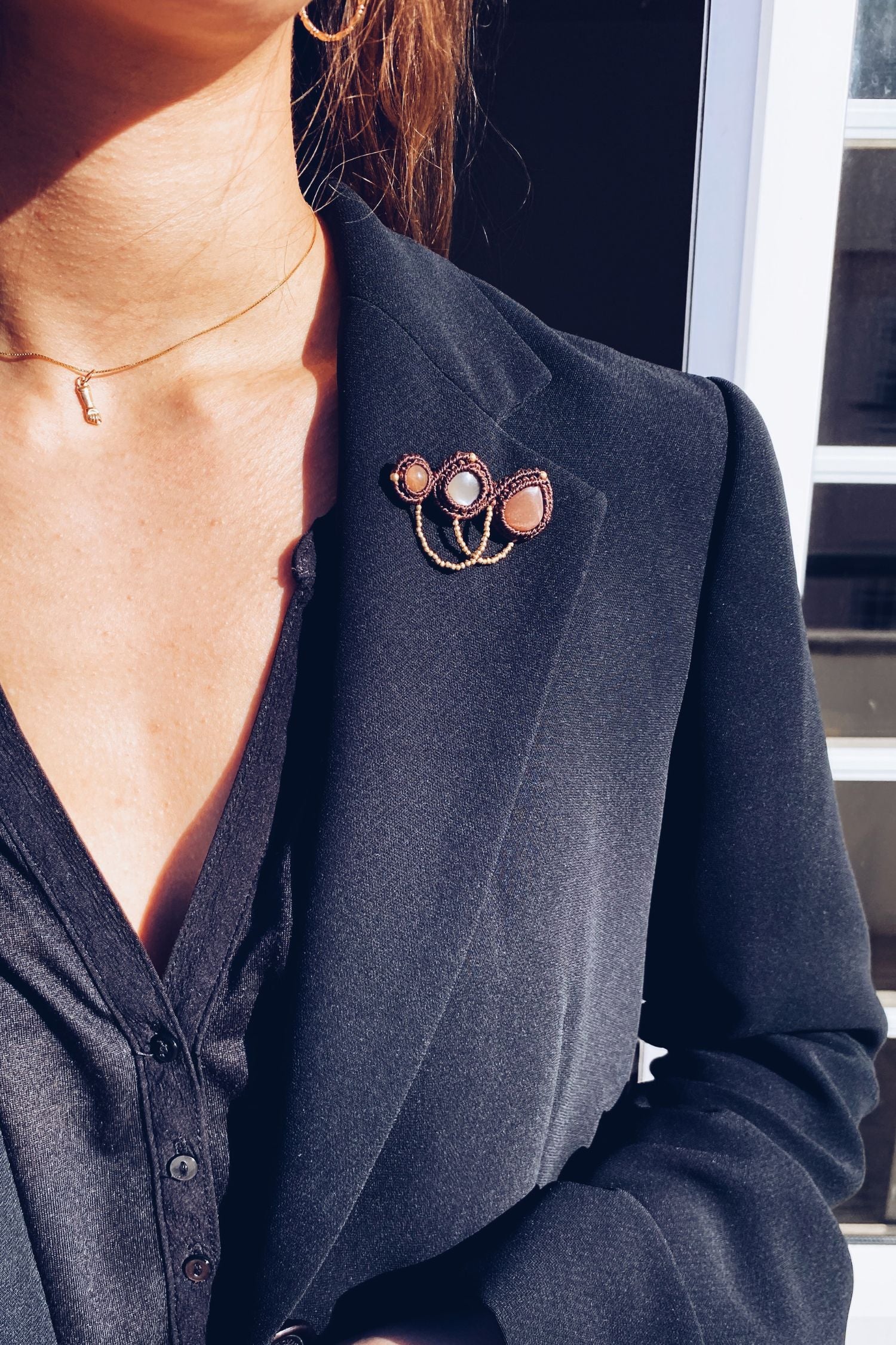 Handmade statement brooch with Peach Moonstone gemstones, styled on a lapel to showcase its elegant and eye-catching design. A versatile accessory that elevates any look.