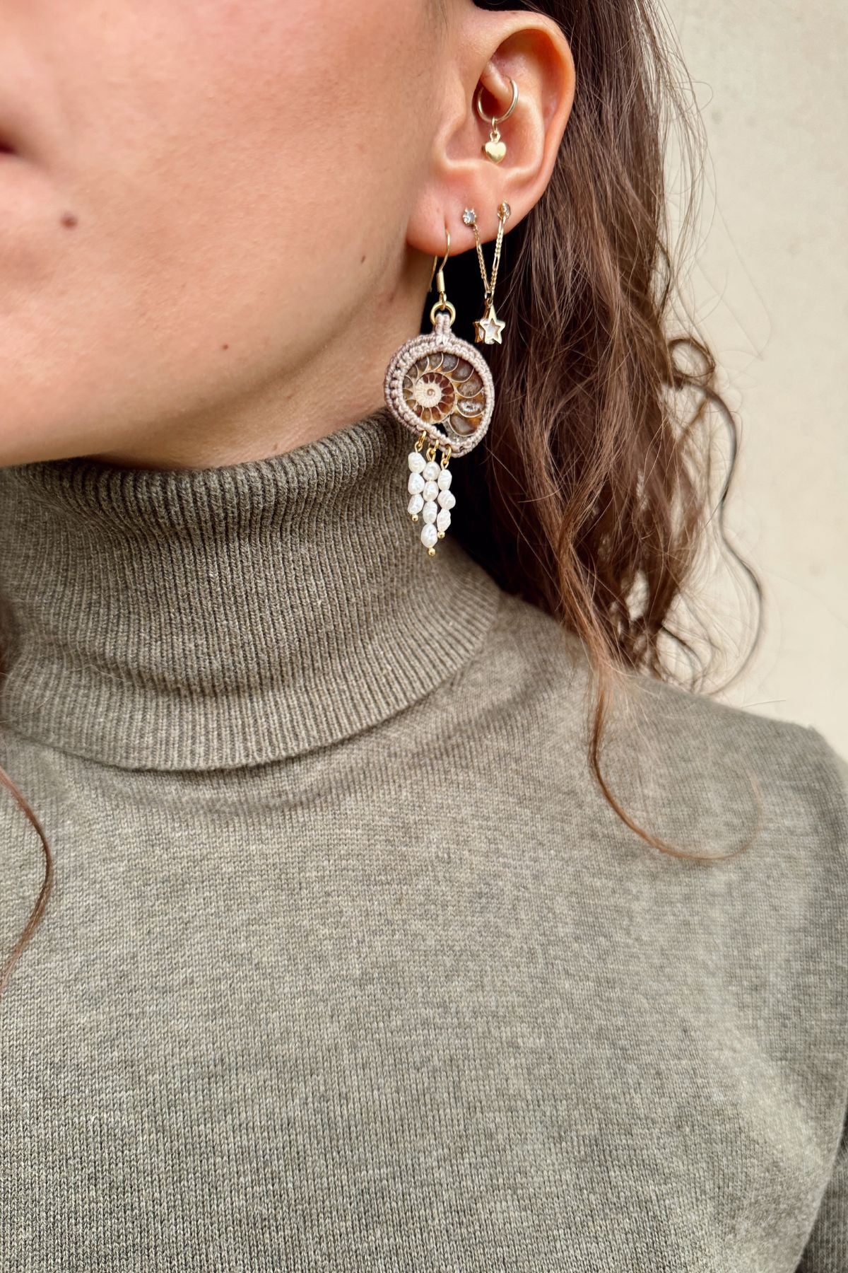 Model wearing sliced ammonite drop earrings with dangling freshwater pearls, elegant and unique statement jewelry