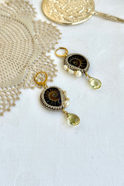Close-up of genuine ammonite fossil earrings with freshwater pearls and translucent lemon quartz drops