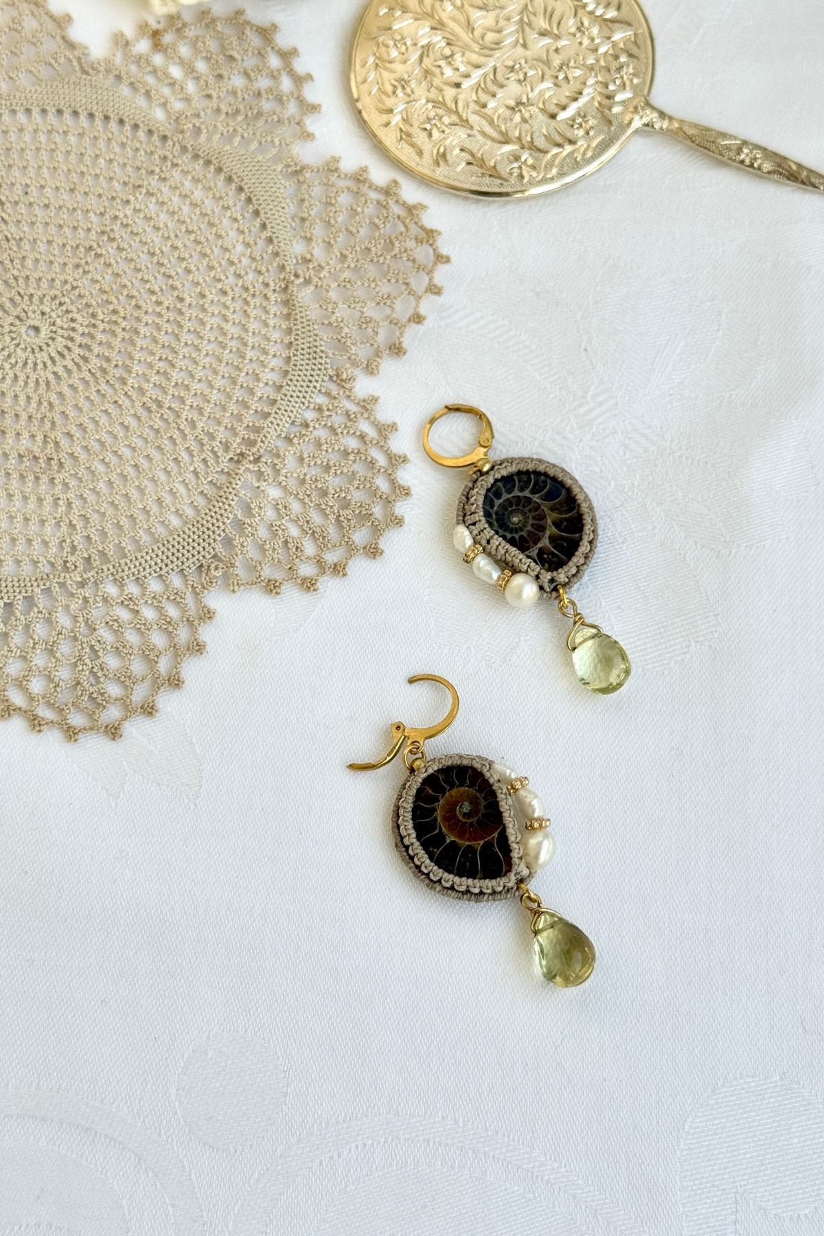 Detail of stainless steel hoop closure on ammonite fossil drop earrings showing secure click opening