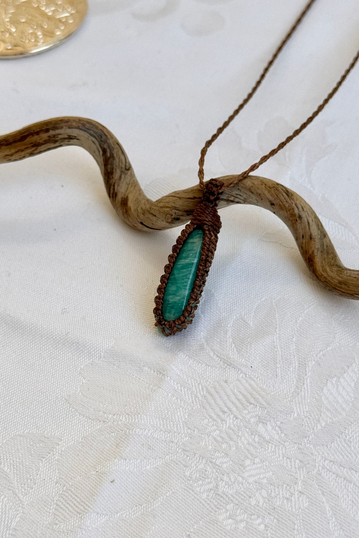Side angle view of the Amazonite Macrame necklace, showing the fine macrame details and the unique gemstone centerpiece.