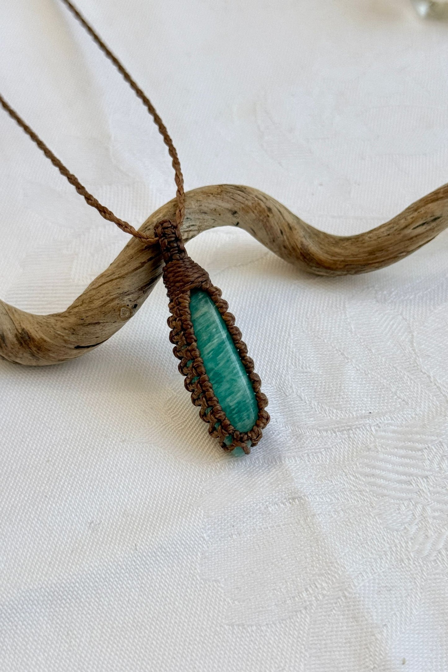 Close-up of handmade Amazonite Macrame necklace, showcasing the intricate macrame knotting and the vibrant patterns of the gemstone.