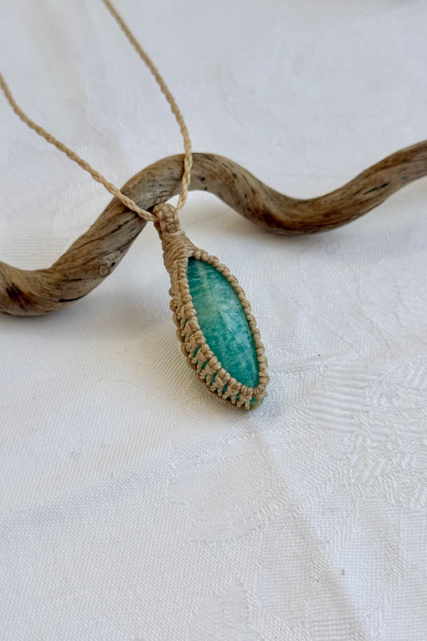 Close-up of handmade Amazonite Macrame necklace, showcasing the intricate macrame knotting and the vibrant patterns of the gemstone.