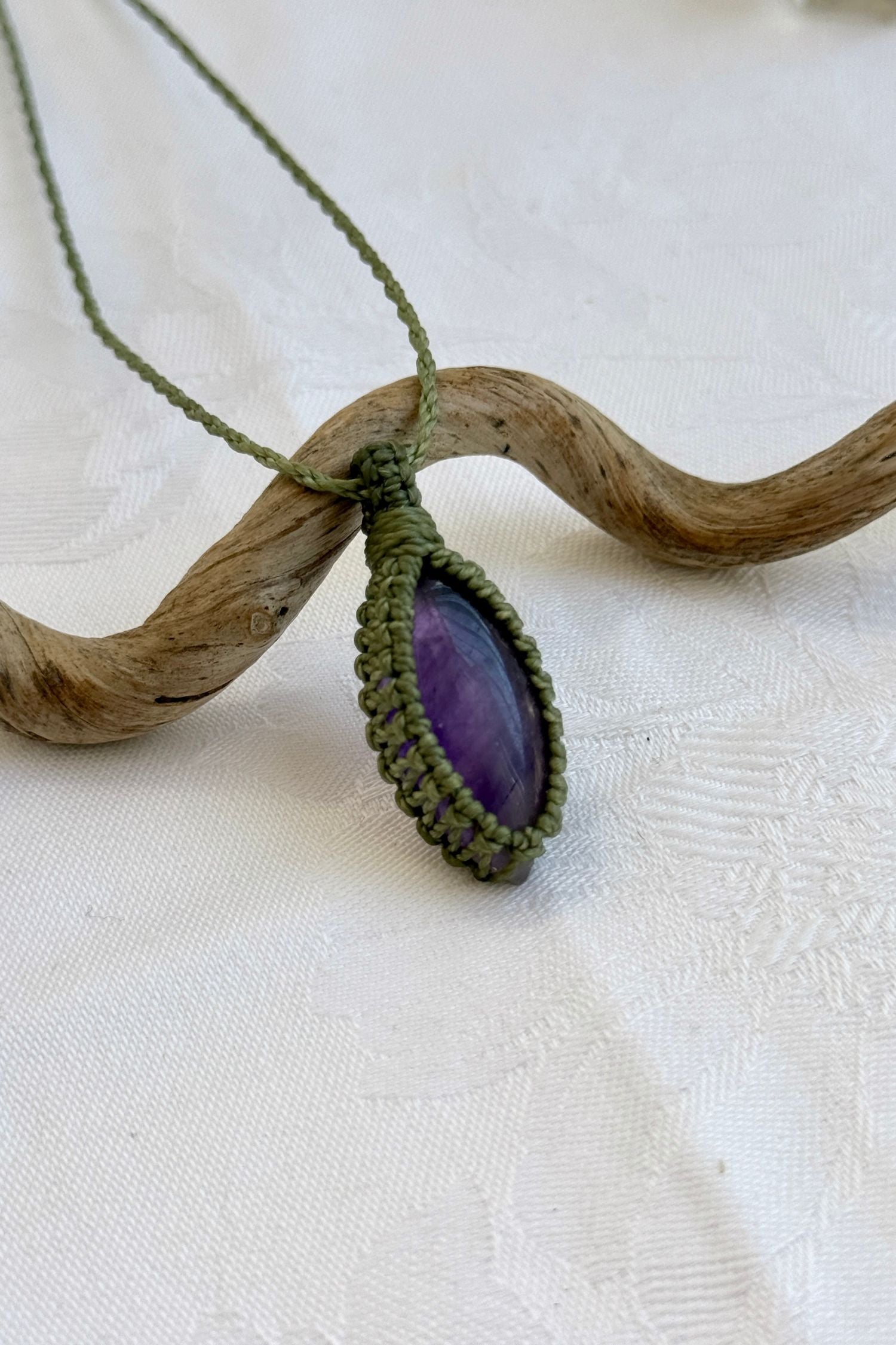 Close-up of handmade Amethyst Macrame necklace, showcasing the intricate macrame knotting and the vibrant patterns of the gemstone.