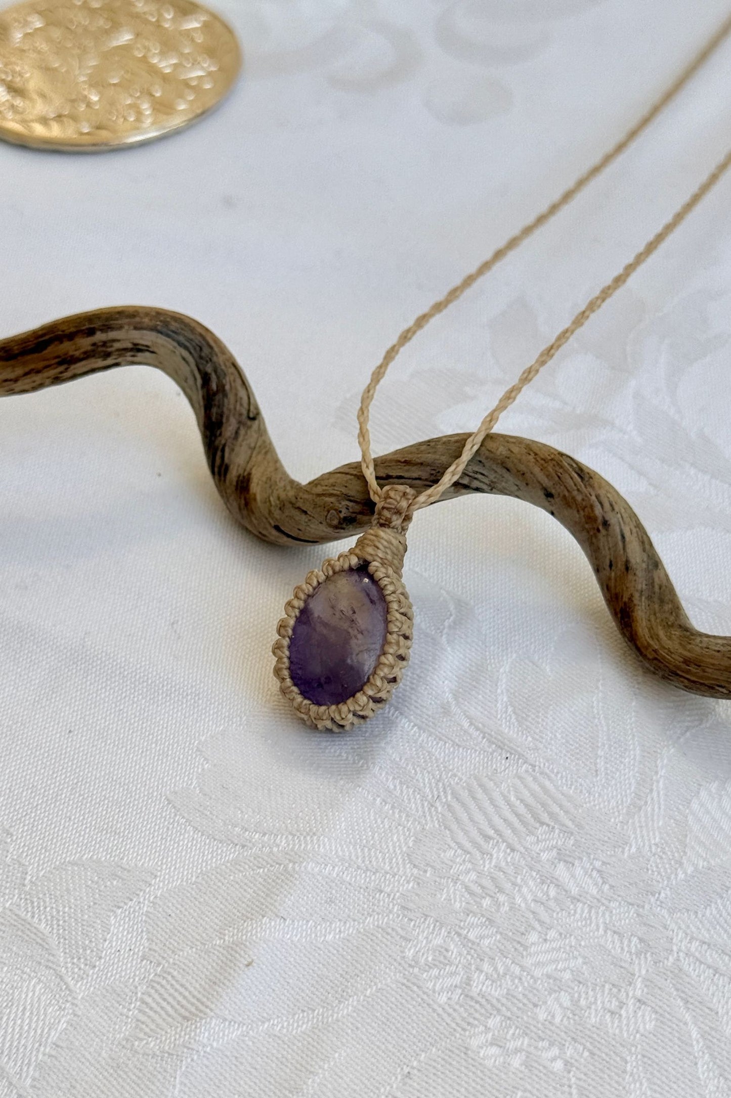 Side angle view of the Ametrine Macrame necklace, showing the fine macrame details and the unique gemstone centerpiece.