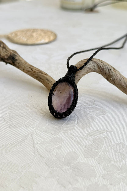 Side view of a Ametrine macrame necklace wrapped in black cord, highlighting its elegant craftsmanship.
