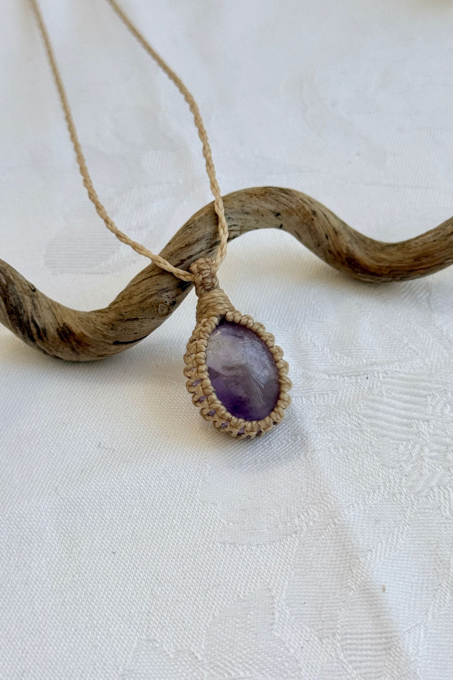 Close-up of handmade Ametrine Macrame necklace, showcasing the intricate macrame knotting and the vibrant patterns of the gemstone.
