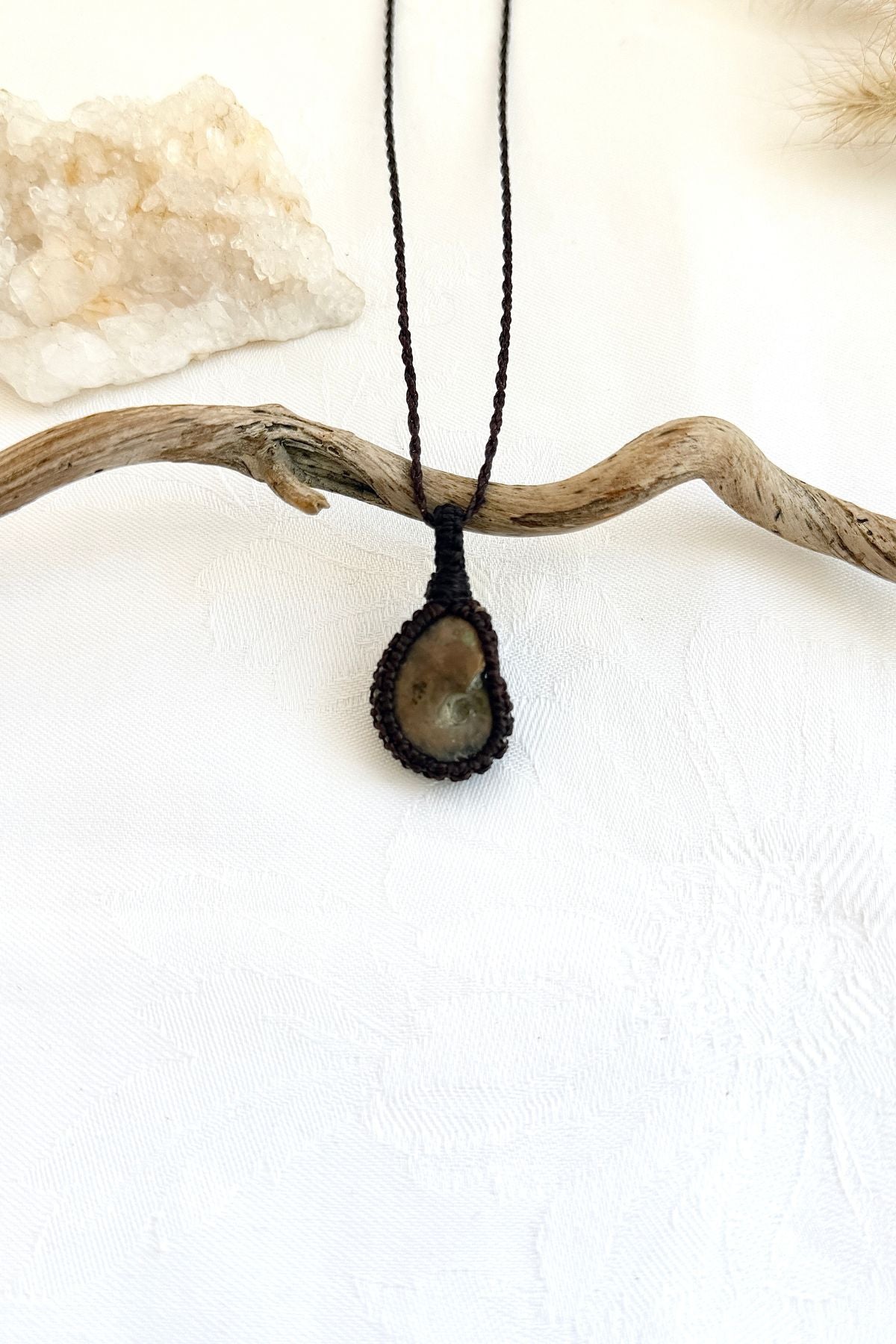 Handmade Ammonite macramé necklace, front view of natural fossil pendant