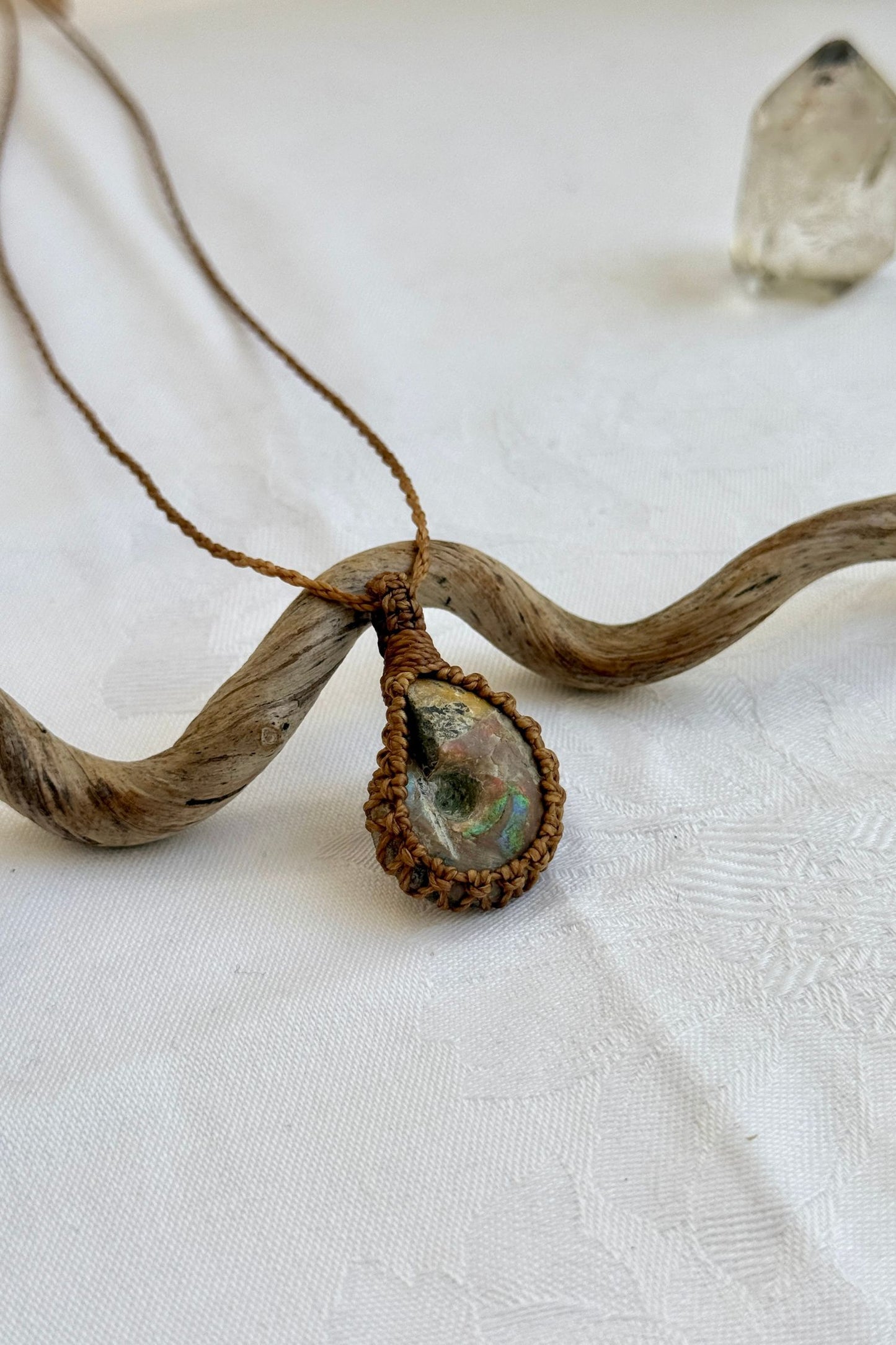 Another side angle shot of the handmade Ammonite Macrame necklace, emphasizing the elegant craftsmanship and natural gemstone colors.