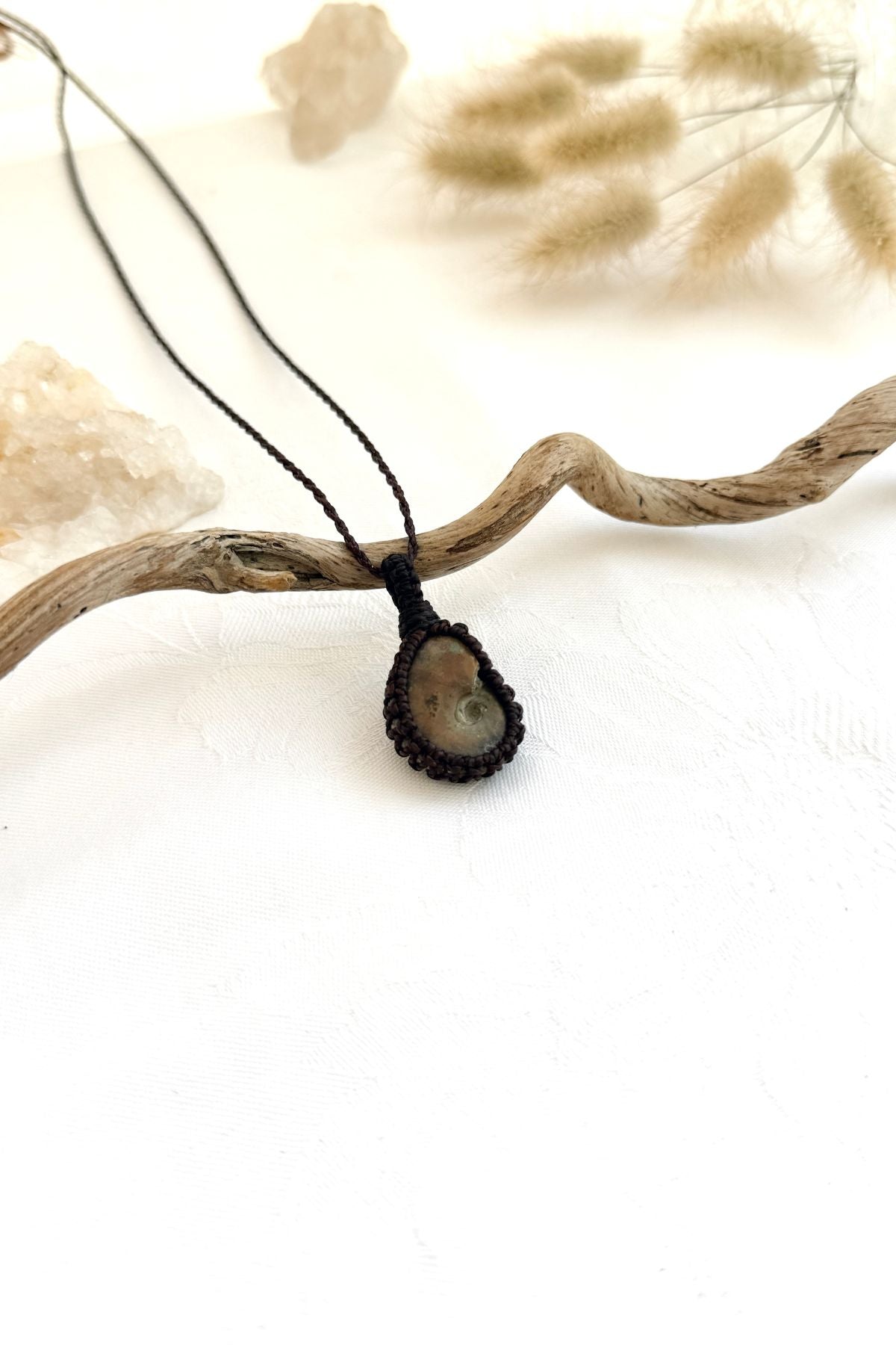 Handmade Ammonite macramé necklace, side view showing the fossil and macramé knotting
