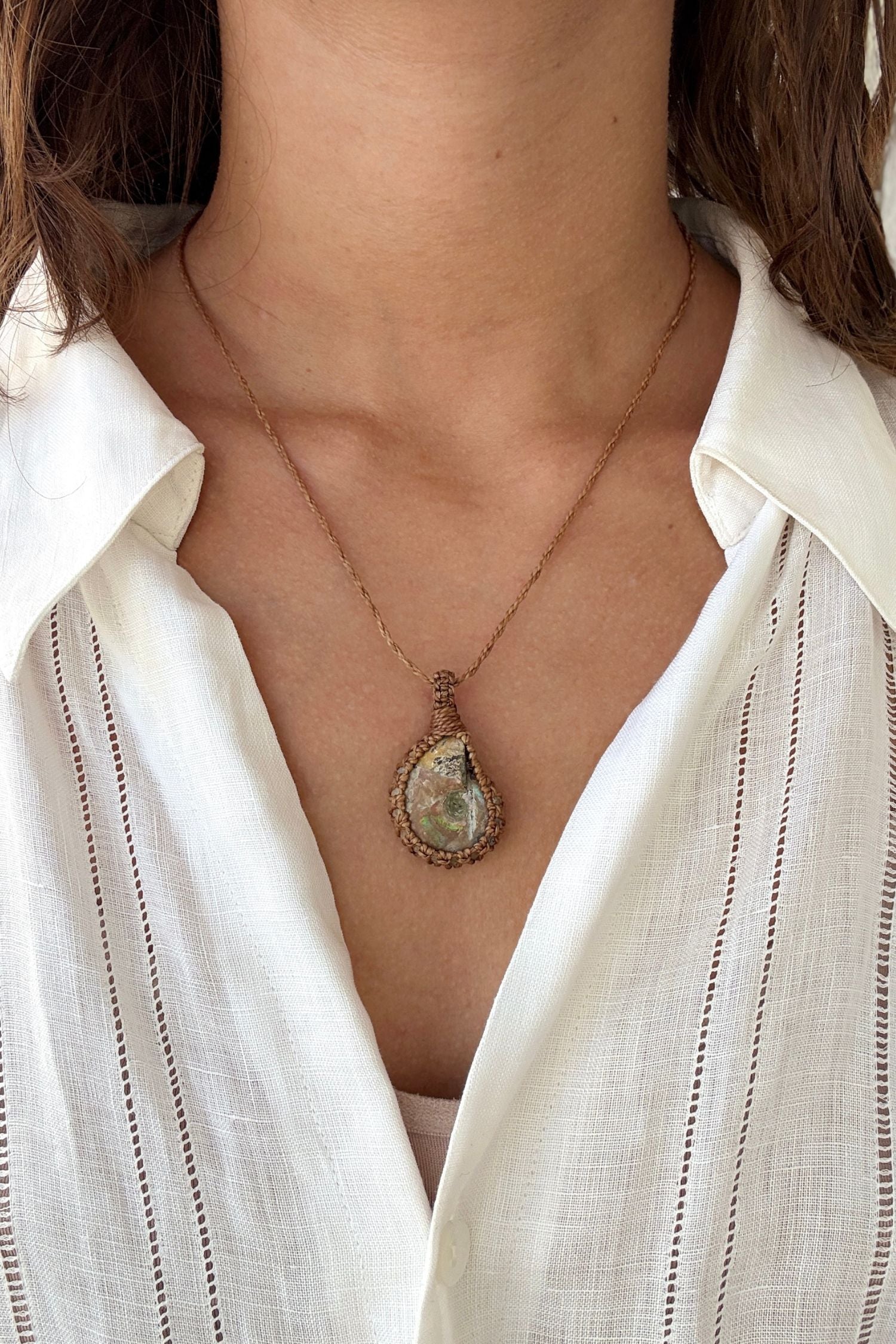 Model wearing a delicate handmade Ammonite macrame necklace with a gold brown cord, perfect for everyday wear.