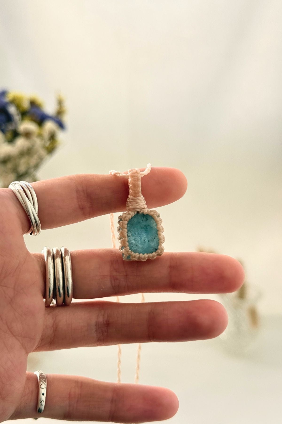 Handmade Aquamarine macramé necklace held in hand, delicate natural gemstone jewelry