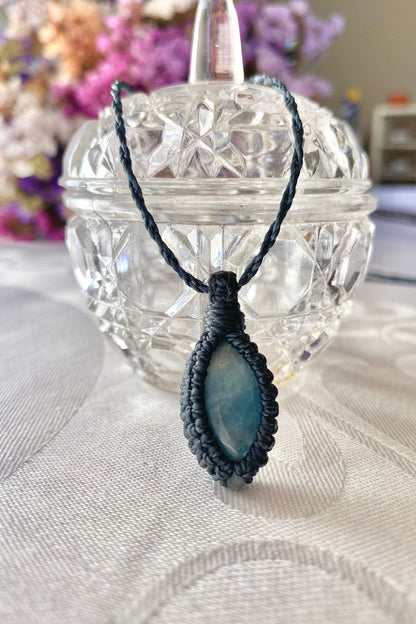 Handmade Aquamarine Macrame necklace displayed standing, highlighting the minimalist macrame design and the natural beauty of the blue gemstone.