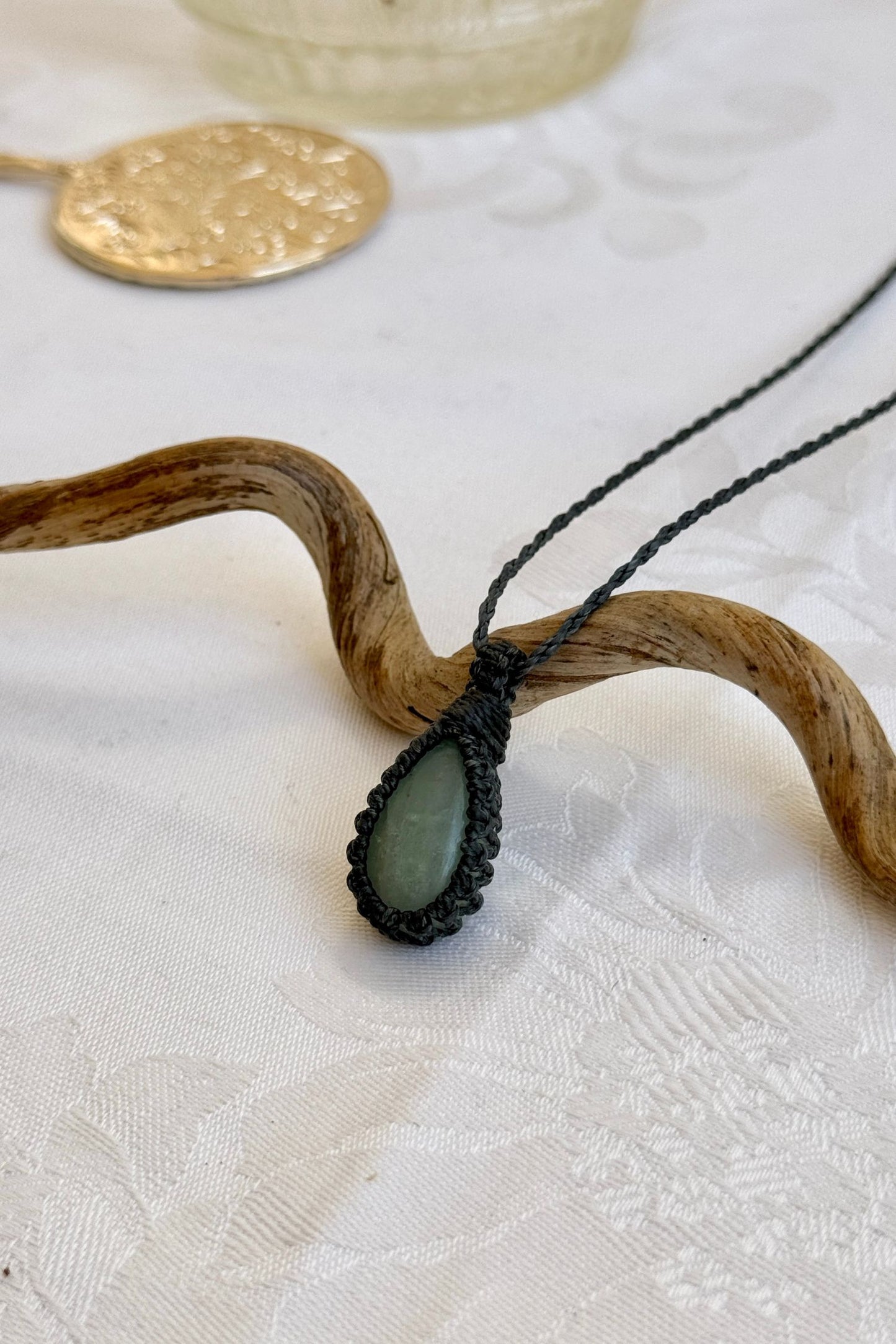Side angle view of the Aquamarine Macrame necklace, showing the fine macrame details and the unique gemstone centerpiece.