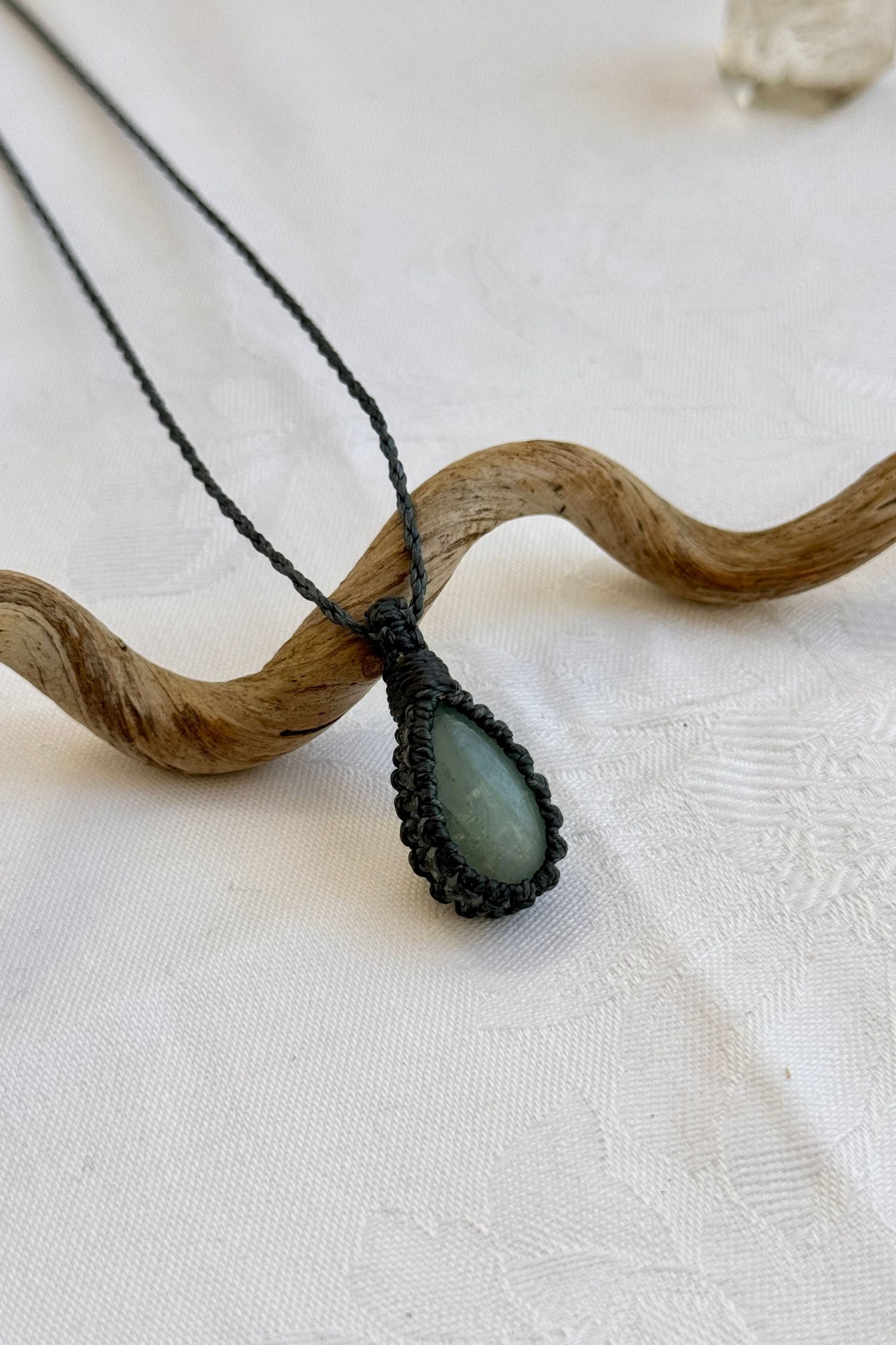 Close-up of handmade Aquamarine Macrame necklace, showcasing the intricate macrame knotting and the vibrant patterns of the gemstone.