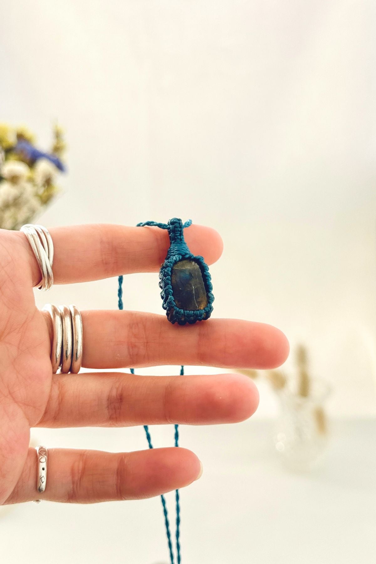Handmade Labradorite macramé necklace held in hand, delicate natural gemstone jewelry