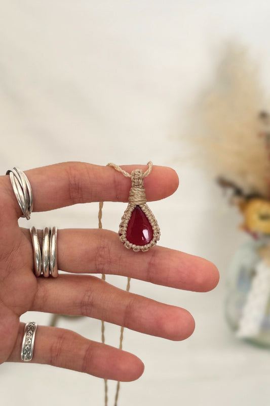 Hand holding a handmade Carnelian Macrame necklace from the Essence collection, featuring a high-quality gemstone in a delicate everyday-wear design.